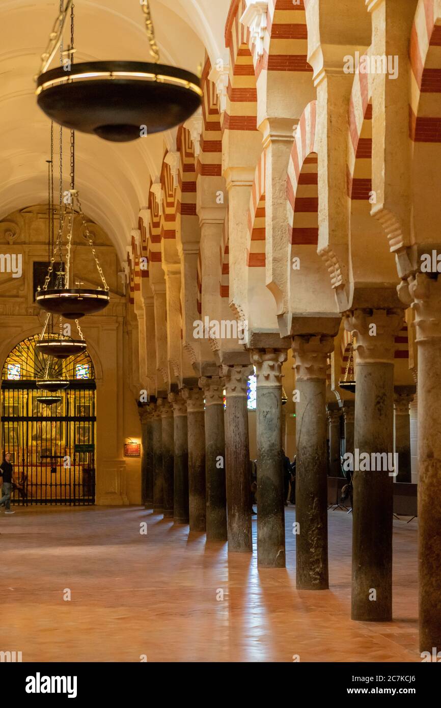 Una fila di archi in cenere a due livelli e mattoni rossi della navata di al-Hakam II conduce attraverso la moschea-cattedrale di Cordova Foto Stock