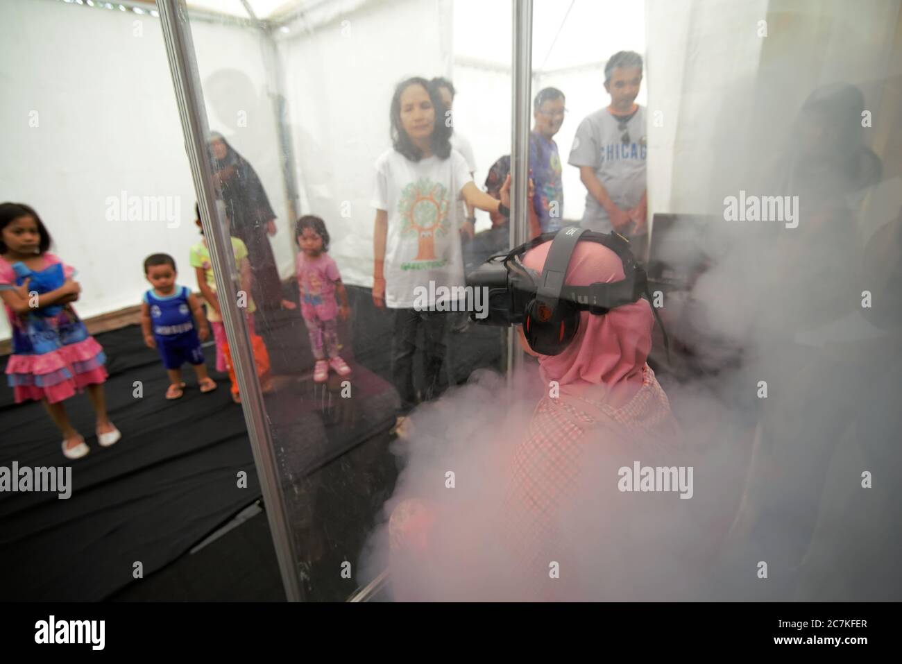Un visitatore che guarda ad una realtà virtuale che mostra sulla ricca biodiversità della foresta tropicale, durante un evento pubblico tenuto da Greenpeace a Giacarta. Foto Stock