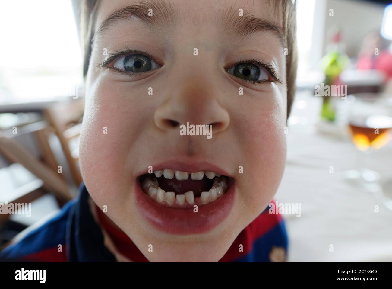 bambino di sei anni che mostra i denti Foto Stock