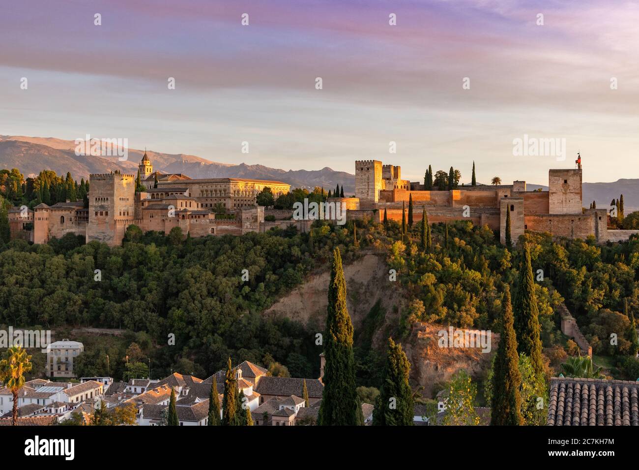 Arroccato sopra la Valle del Darro, il sole serale illumina la spettacolare Alhambra di Granada, con la Sierra Nevada in lontananza. Foto Stock