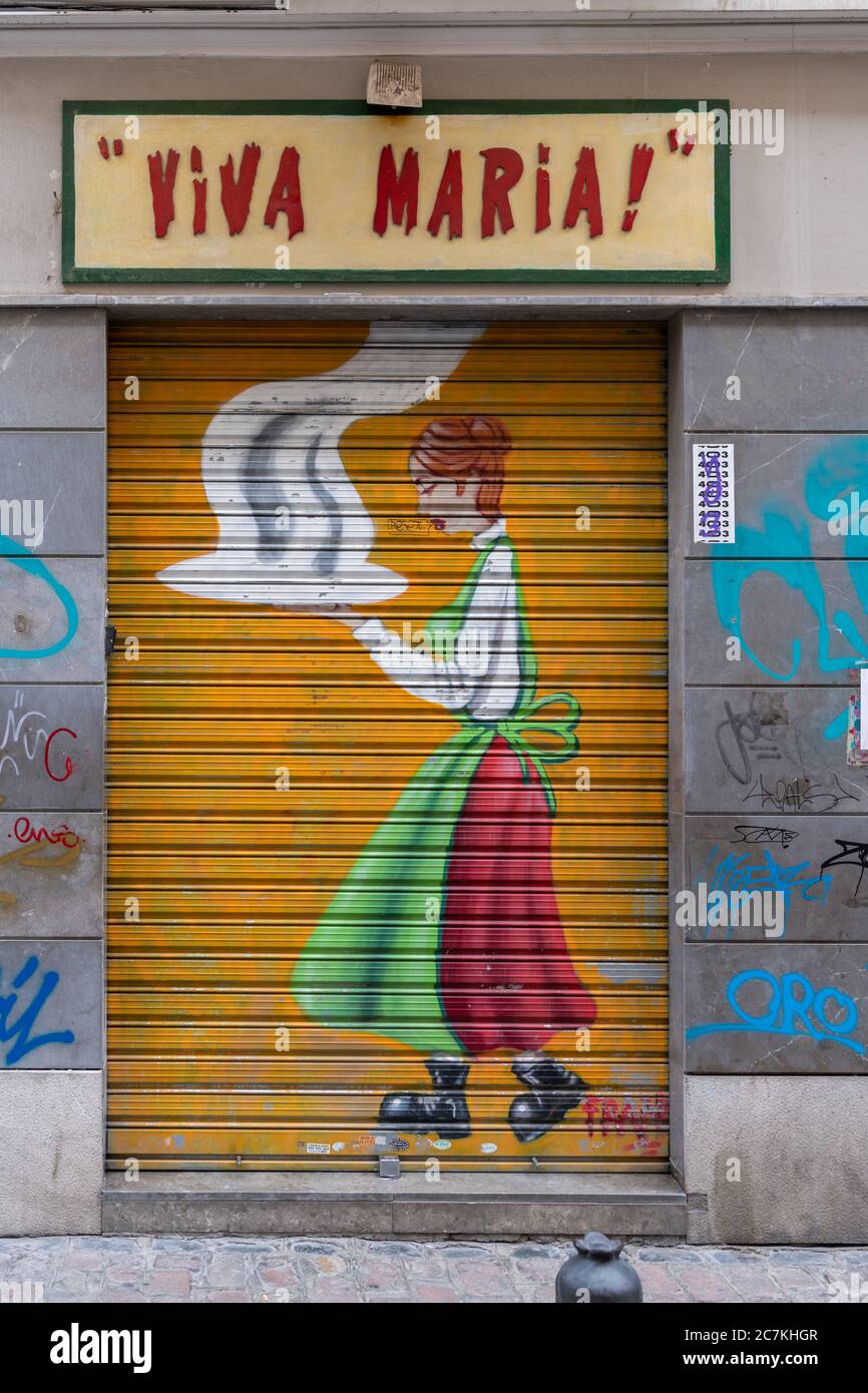 Un murale colorato di una cameriera con un piatto fumante, dipinto sulle persiane del ristorante italiano Viva Maria in Calle de San Jeronimo a Granada Foto Stock