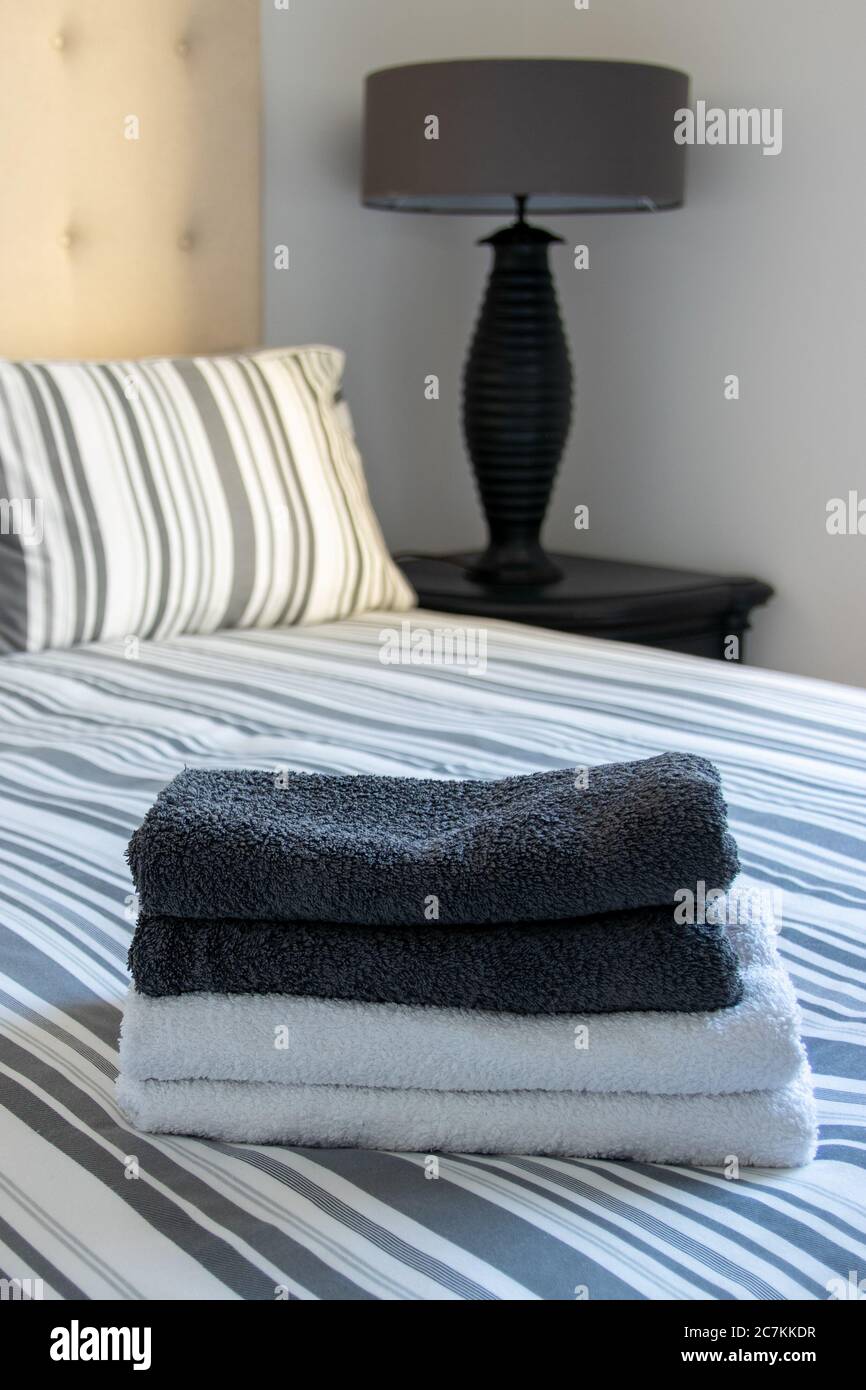 asciugamani posati su un letto da una cameriera in un camera d'albergo Foto Stock