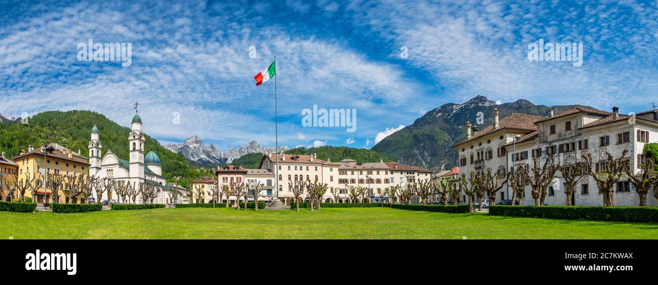 Il centro di Agordo con la chiesa con due campanili e il grande prato verde chiamato 'BROI', agordino, belluno, veneto, italia Foto Stock