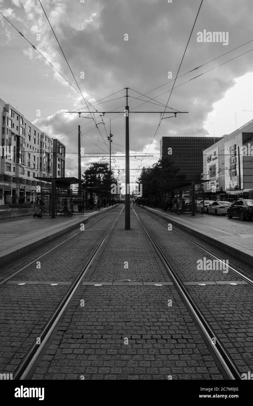Immagine verticale in scala di grigi delle rotaie della città Foto Stock