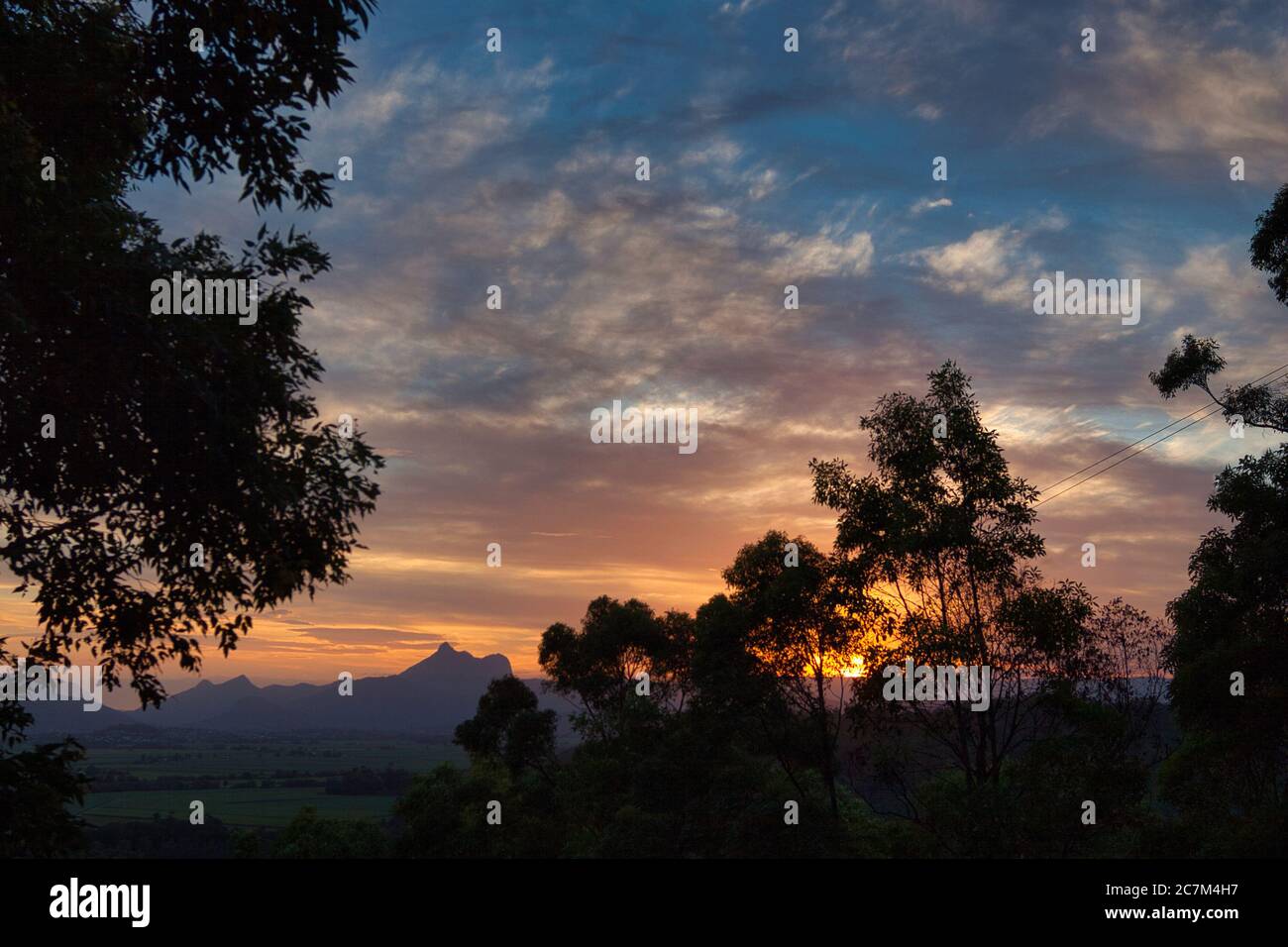 La vetta del Mount Warning prende il nome dal Capitano Cook, silhouette al tramonto sulla costa medio orientale del New South Wales, Australia. Foto Stock