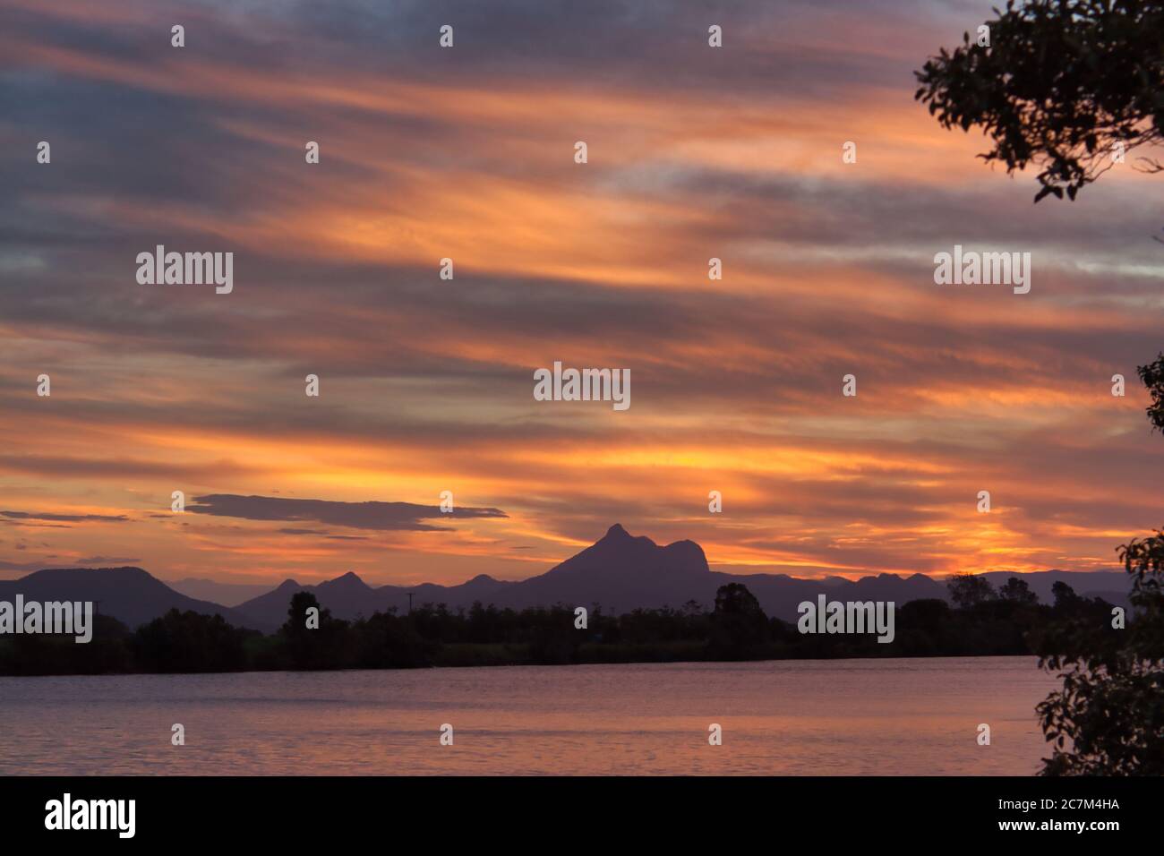 La vetta del Mount Warning prende il nome dal Capitano Cook, silhouette al tramonto sulla costa medio orientale del New South Wales, Australia. Foto Stock