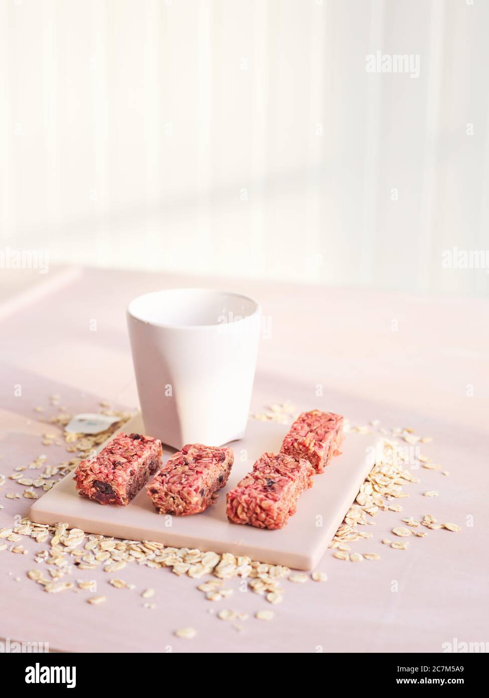 una piccola piastra quadrata di barre di cereali e una tazza Foto Stock