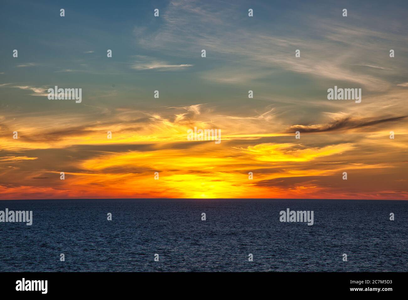 Tramonto incantevole sul mare con il sole appena passato sopra l'orizzonte Foto Stock
