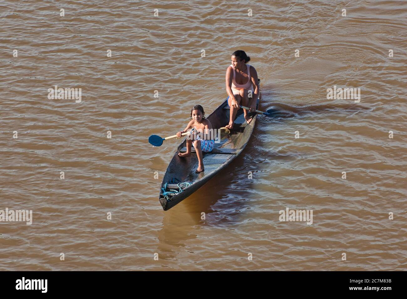 Una madre e sua figlia pagaiano una canoa di legno sul fiume Amazzonia vicino a Belem, nello Stato di Para, Brasile. Foto Stock