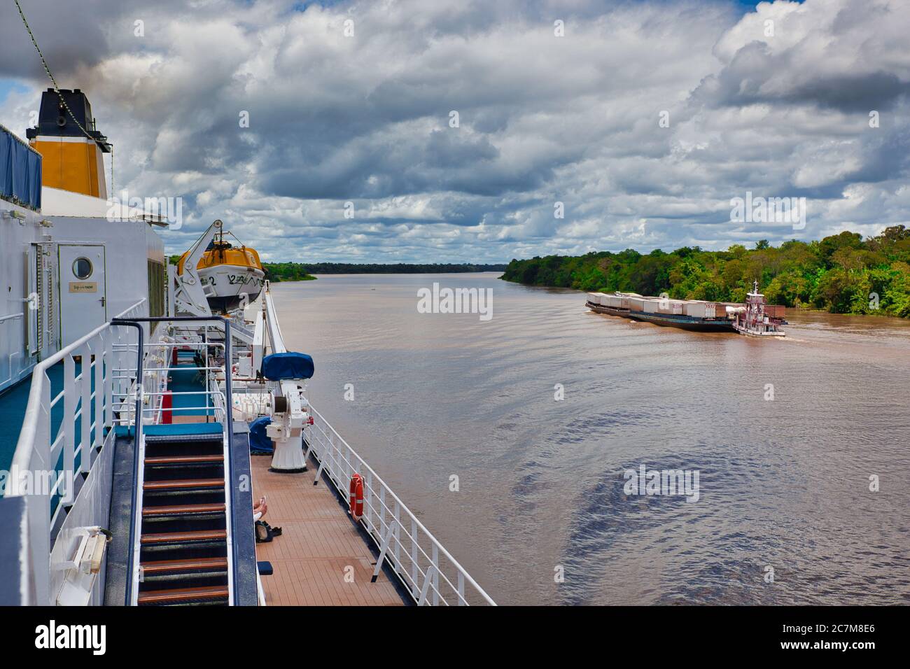 Da una grande nave sul fiume Amazzonia del fiume e una grande chiatta piena di contenitori oceanici andando l'altro senso vicino a Belem, Stato di Para, Brasile Foto Stock
