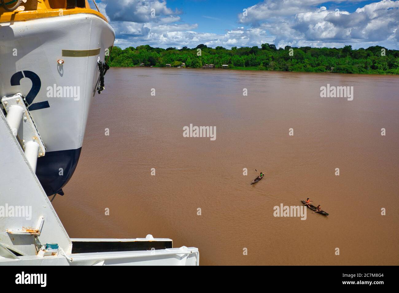 Vista da vicino a una barca di salvataggio del fiume Amazzonia con due canoe in legno aperto sul fiume nelle vicinanze e la foresta pluviale oltre, nello stato di Para, Brasile Foto Stock