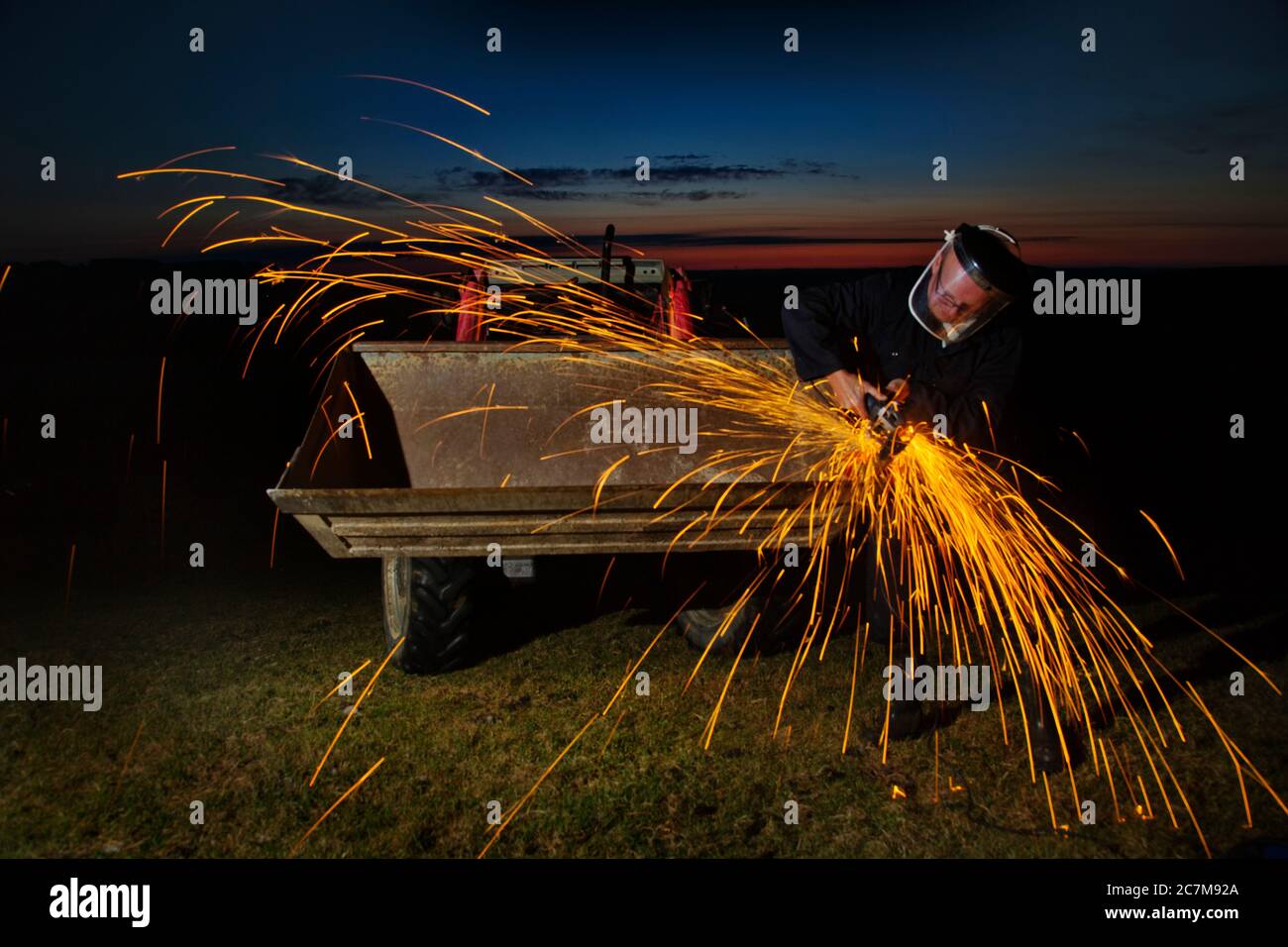 Operaio agricolo che usa il macinacaffè dell'angelo alla notte. Foto Stock