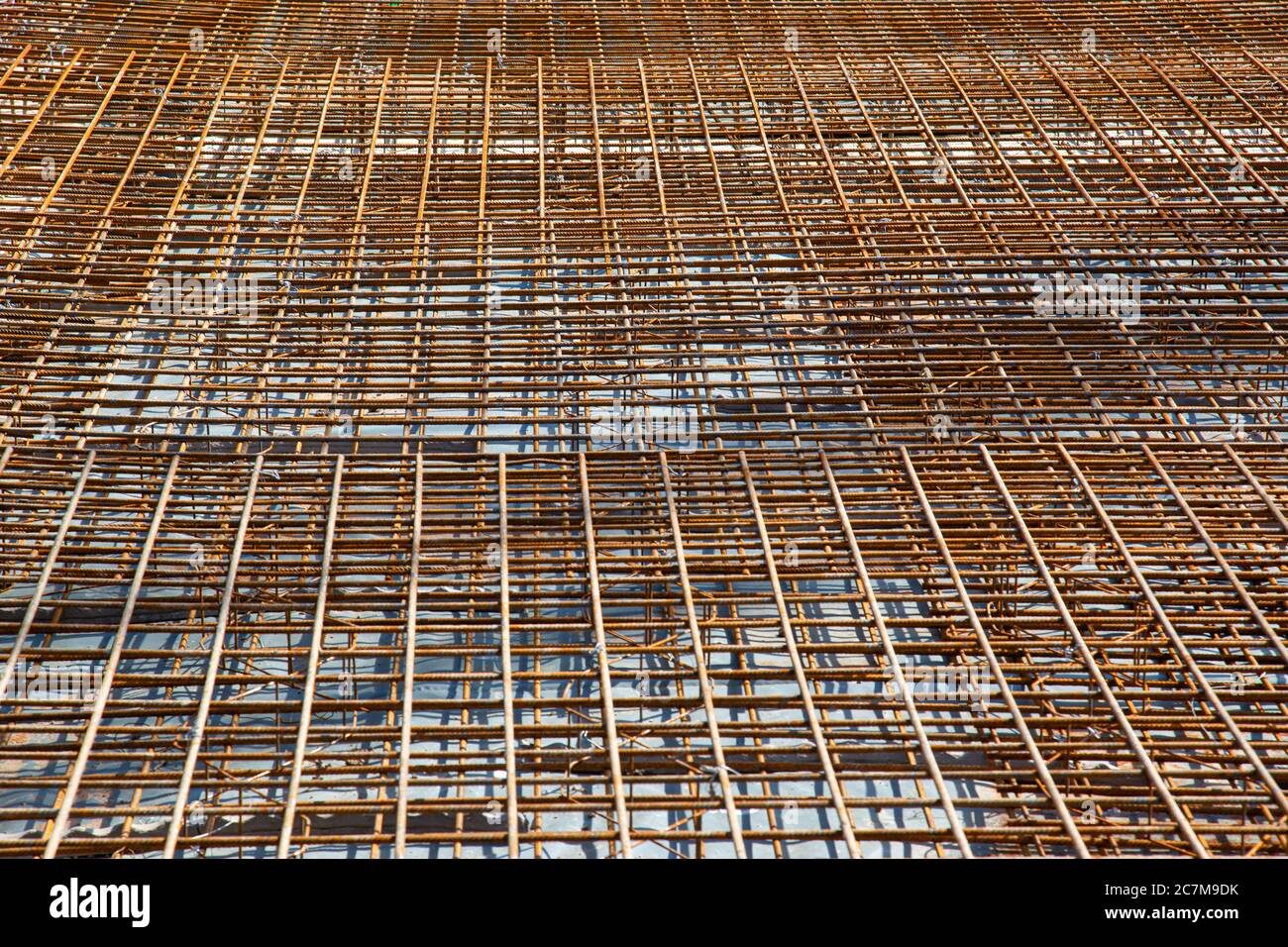 Tappetini in rete di rinforzo arrugginiti preparati per una piastra di base in un cantiere Foto Stock