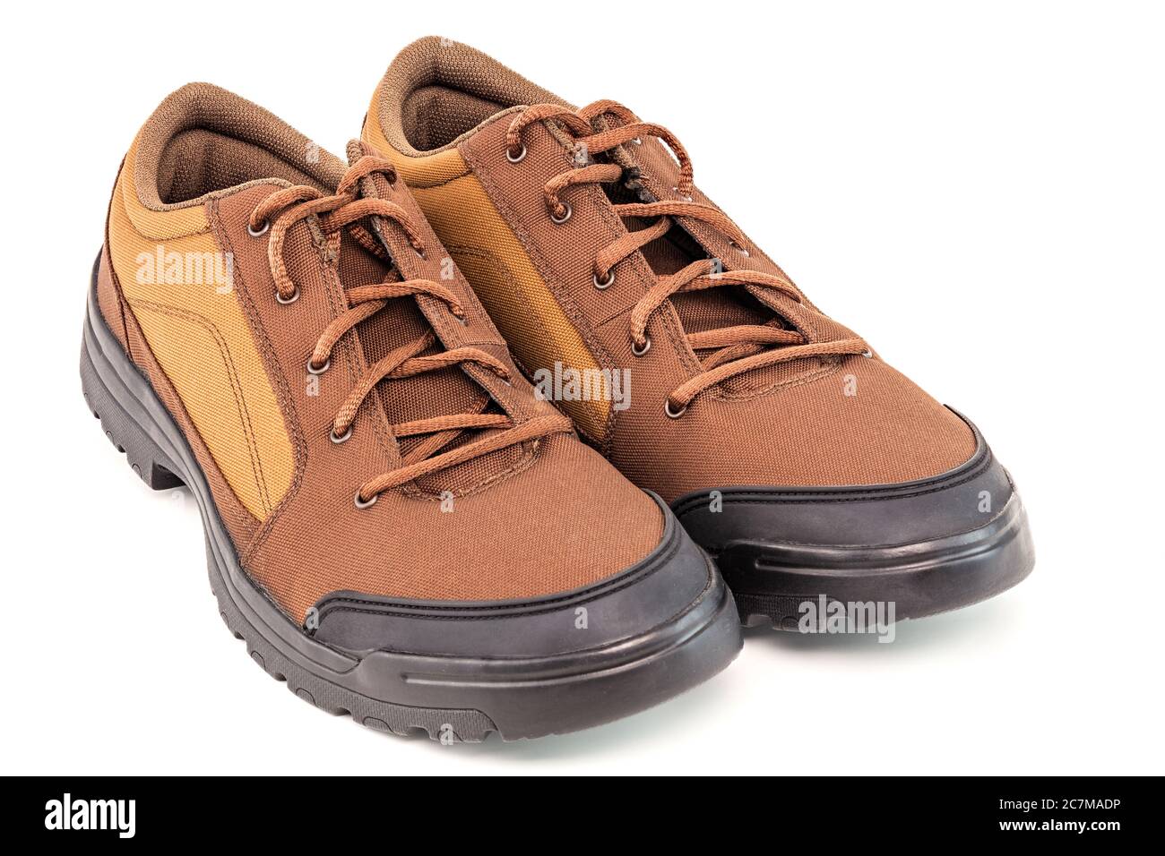 un paio di scarpe da viaggio marrone a basso costo in tessuto resistente isolato su sfondo bianco Foto Stock