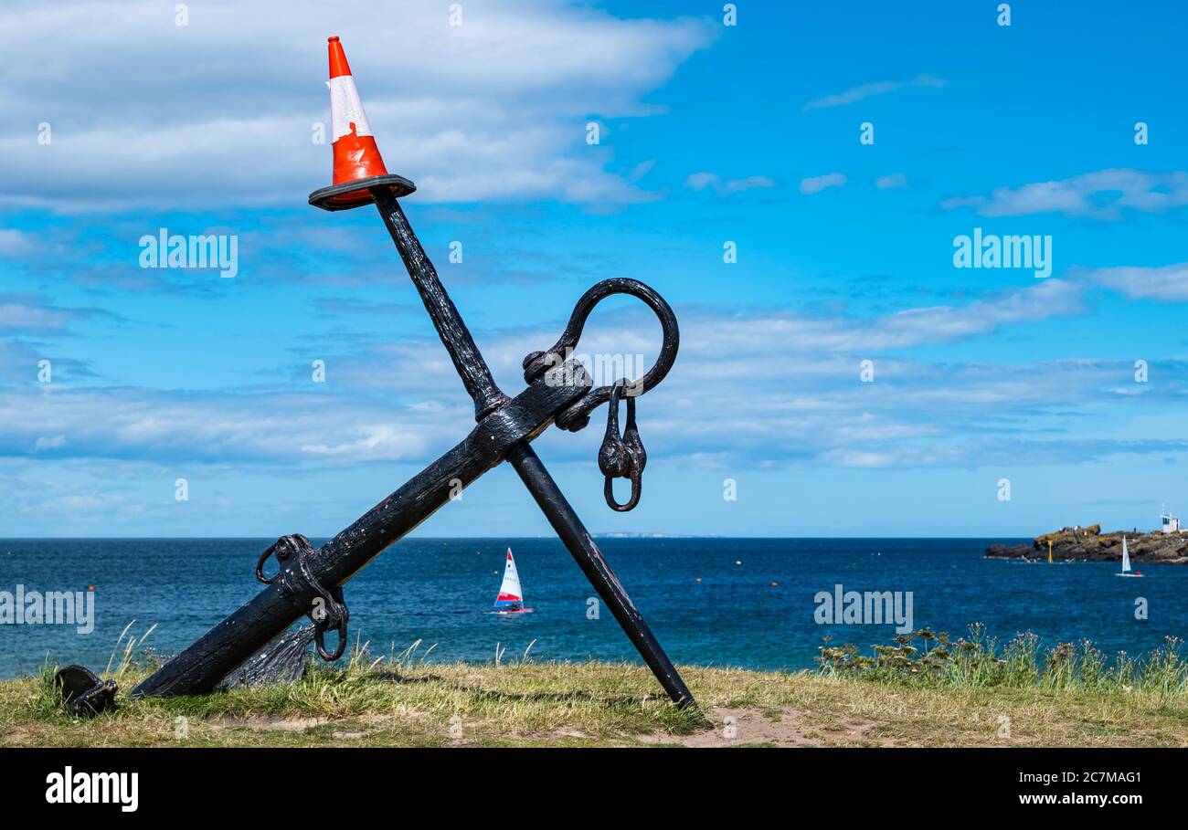 North Berwick, East Lothian, Scozia, Regno Unito, 18 luglio 2020. Regno Unito tempo: Sole estivo nella città di mare. Il punto di riferimento dell'ancora locale sulla spiaggia di Elcho Green by West è decorato con un cono di traffico Foto Stock