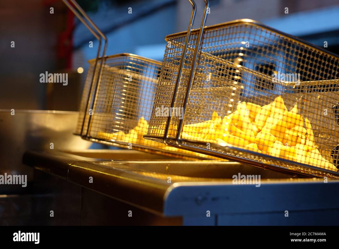 Foto ad angolo ridotto di deliziose patatine fritte su un friggitrice profonda in acciaio inox Foto Stock