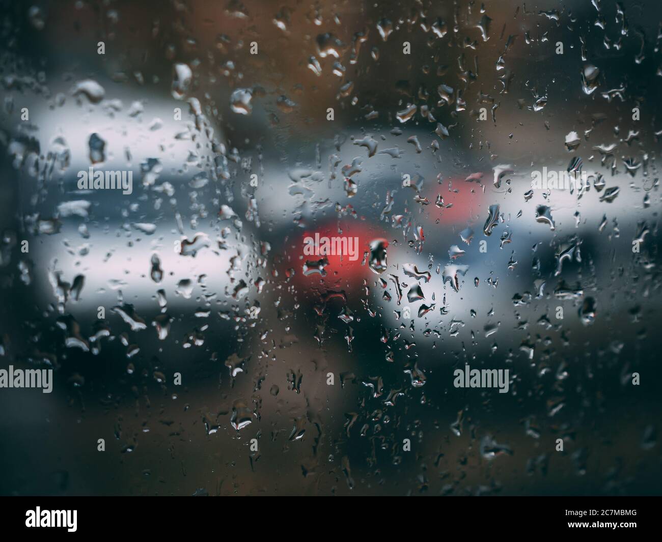 Gocce d'acqua sulla finestra dopo la pioggia con sfocato auto viste da esso Foto Stock