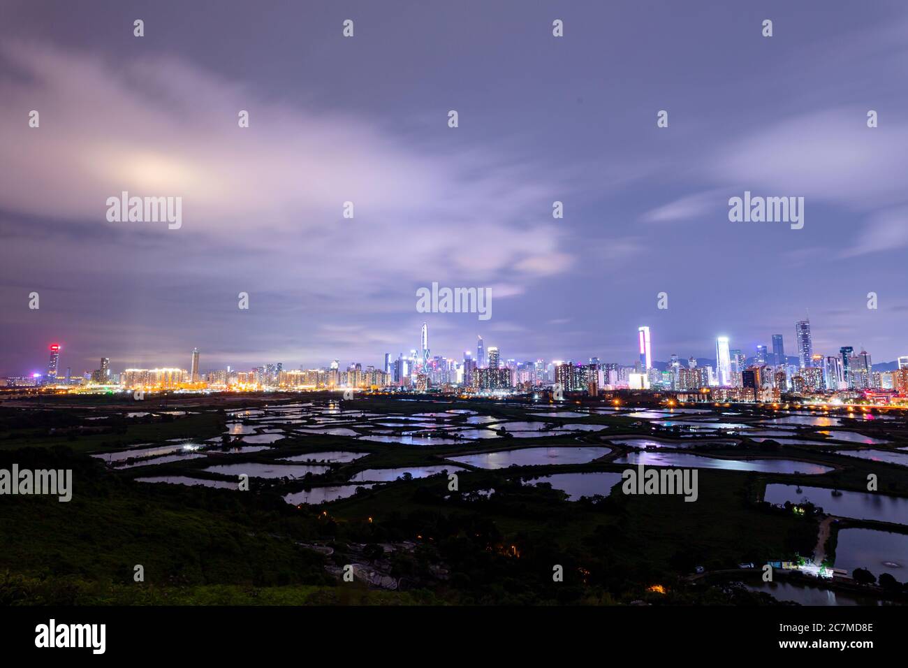 La vista di Shenzhen da ma Tso Lung, Hong Kong. Guarda i grattacieli di Shenzhen dietro il laghetto di pesci situato a Hong Kong, che si separa dal fiume Shenzhen. Foto Stock