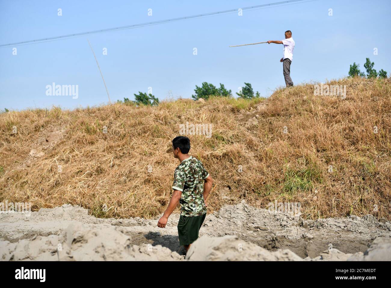 (200718) -- JIUJIANG, 18 luglio 2020 (Xinhua) -- Zhang Heng e suo padre pattugliano l'argine insieme nella città di Jiujiang, nella provincia di Jiangxi della Cina orientale, 17 luglio 2020. Zhang Heng, 27 anni, era un tempo membro delle guardie nazionali. Scelse di tornare nella sua città natale per lavorare come agricoltore e prendersi cura dei suoi genitori dopo aver terminato il suo servizio militare. Anche se i suoi 60 mu (circa 4 ettari) campi sono stati gravemente danneggiati da inondazioni quest'anno, Zhang Heng attivamente Uniti negli sforzi di controllo delle inondazioni insieme con suo padre. "Io ero solito a custodire l'onore e la dignità del mio paese, e ora sono guar Foto Stock