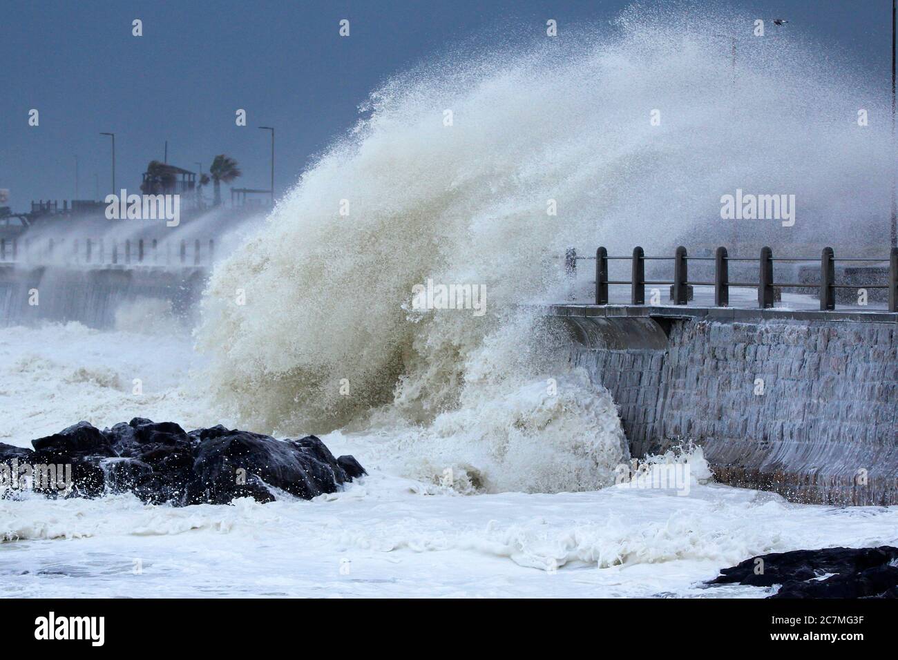 Onde tempeste enormi che si infrangono nel muro di mare di Città del Capo durante un'intensa tempesta invernale. Foto Stock