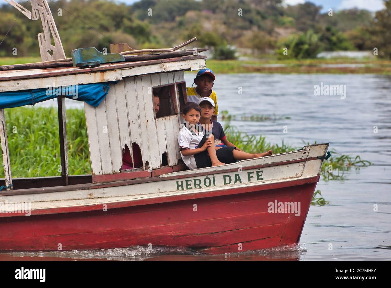 Tre ragazzi su una piccola barca nel villaggio di Boca De Valeria sul Rio delle Amazzoni, stato di Amazonas, Brasile. Foto Stock