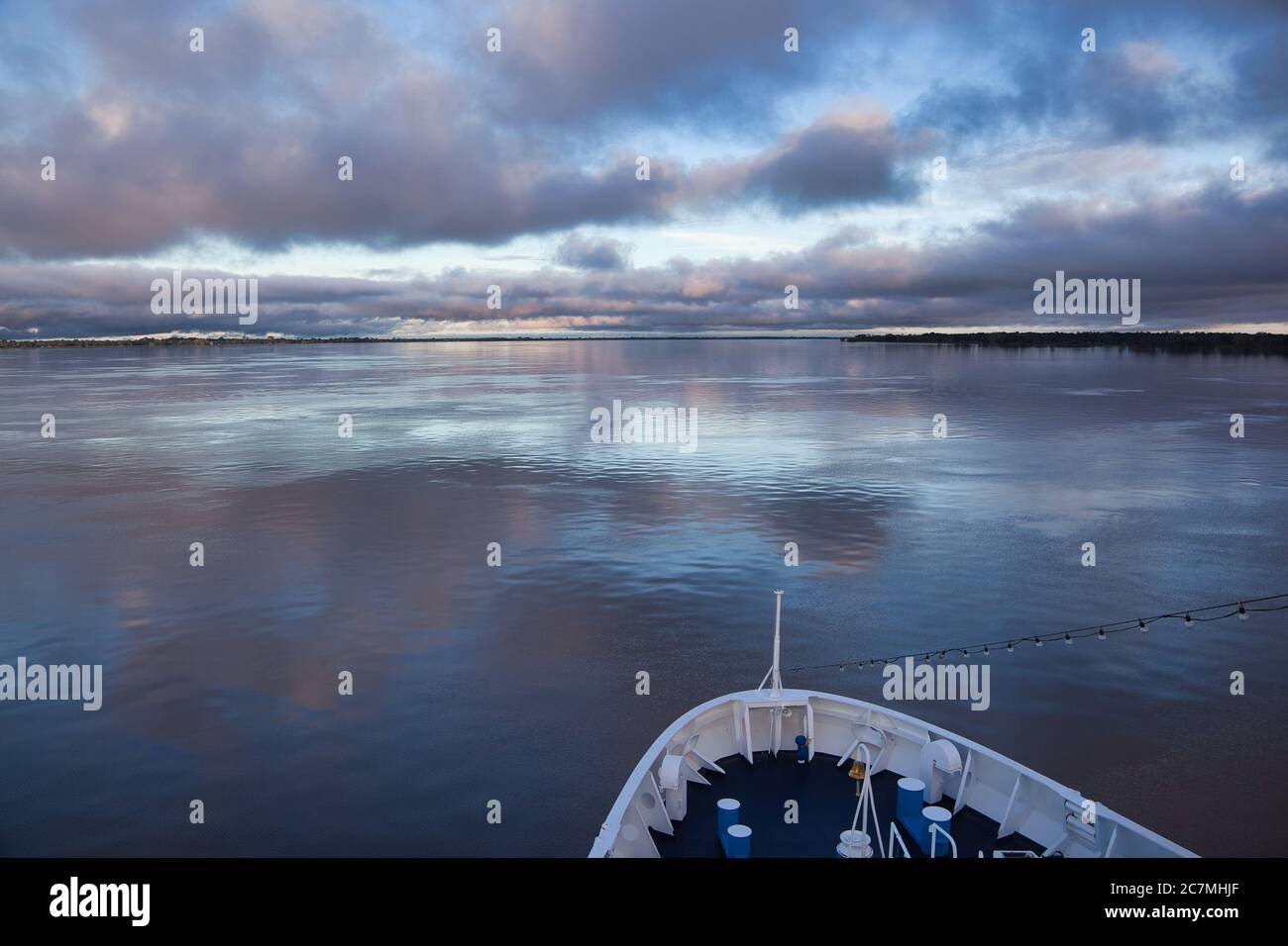 Vista dalle fibbie di una nave del fiume Amazzonia in una giornata molto tranquilla, con bei riflessi del cielo e delle nuvole nella superficie liscia dell'acqua Foto Stock