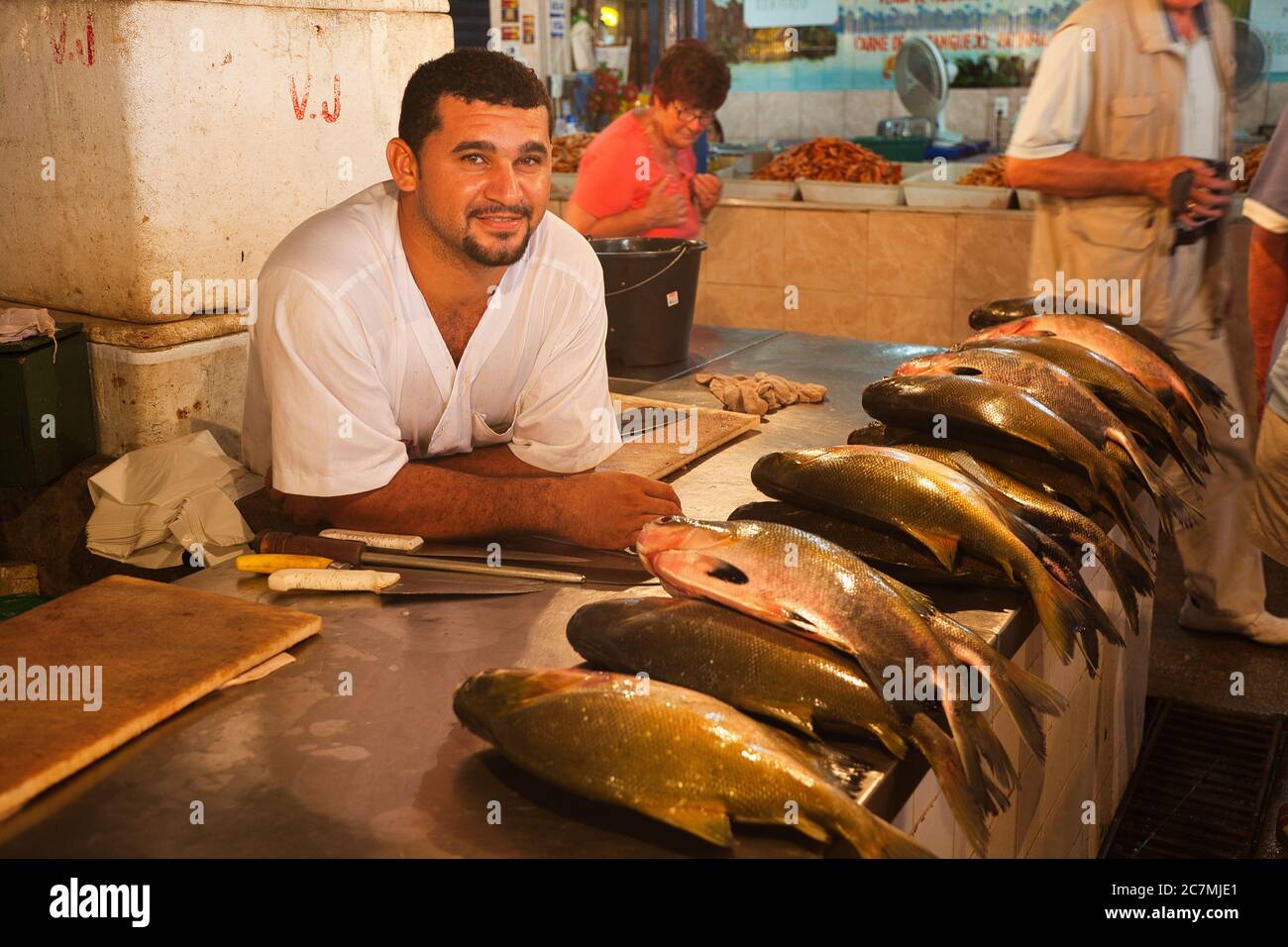 Un uomo al suo stallo nel mercato con pesce fresco pescato, appoggiandosi sul banco e guardando la macchina fotografica, a Manaus, Amazonas Stato, Brasile Foto Stock