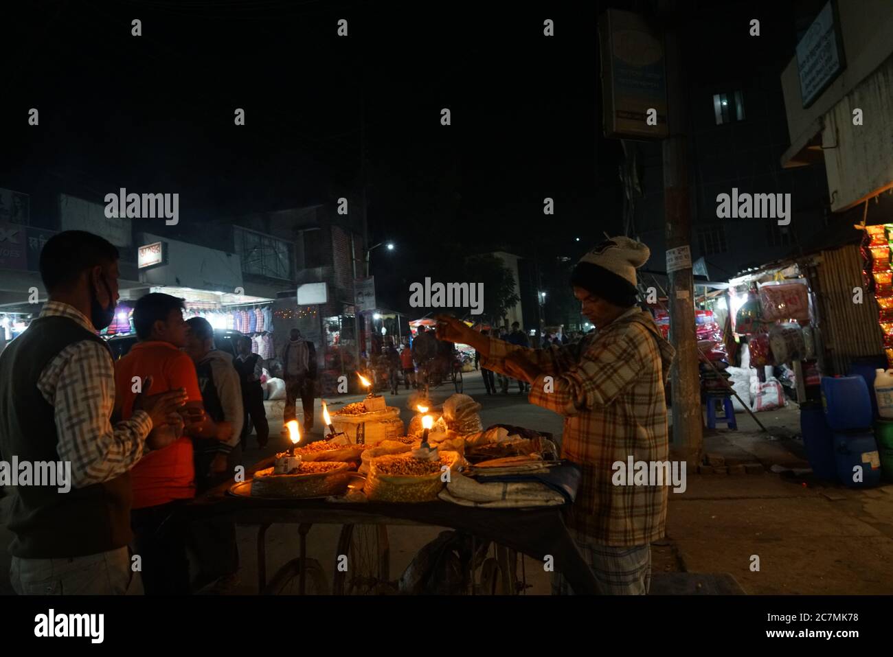 Vendor di frutta nel mercato locale a Bandarban, Chittagong Hill Tracts, Dhaka vende i suoi prodotti in serata ai clienti alla luce di una lampada a fiamma aperta kerosene. Foto Stock