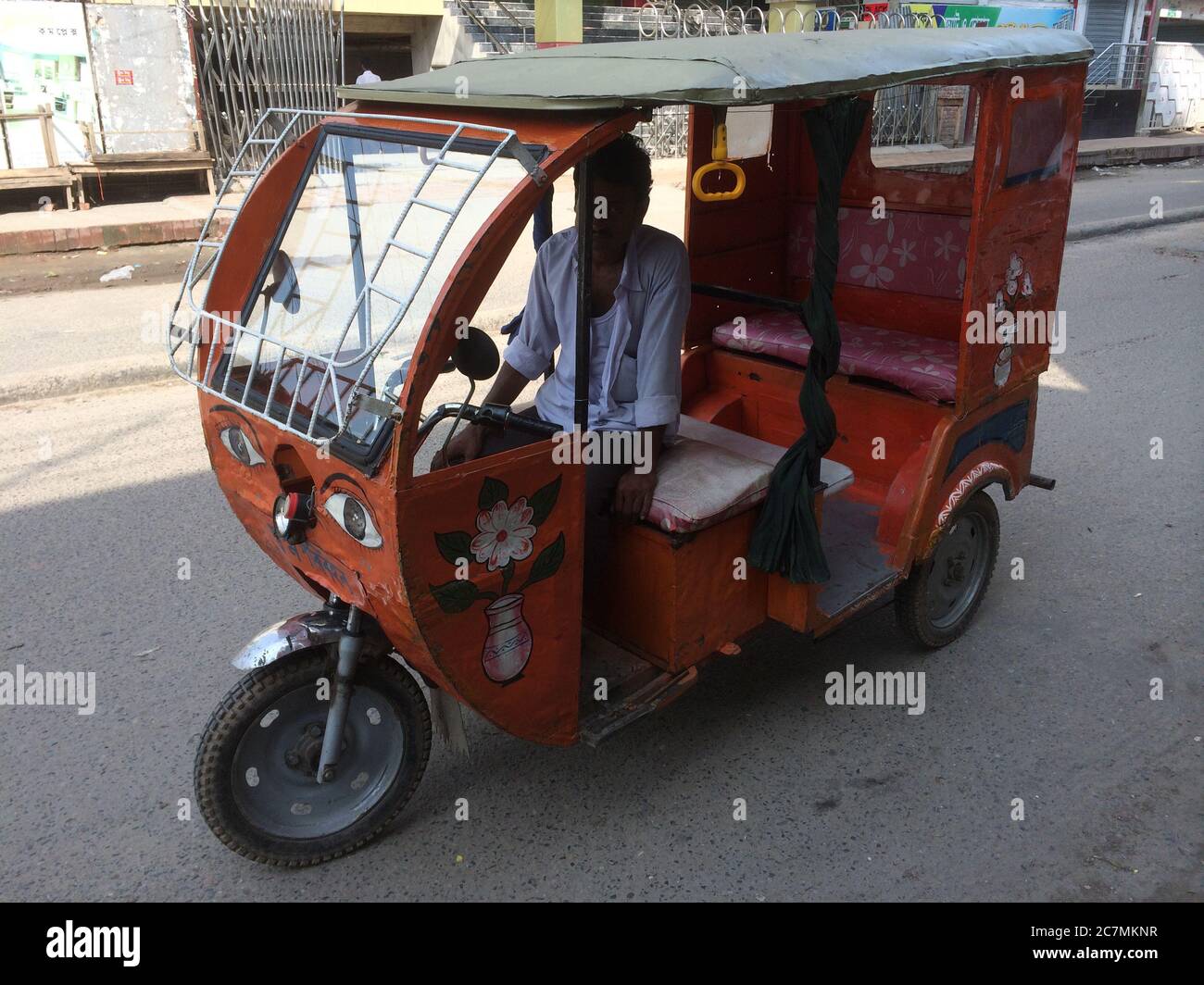 Un taxi ‘Mauto a batteria, costruito localmente, a Manikganj, in Bangladesh, conosciuto come 'Sshuk', è stato decorato dal suo proprietario-autista. Questi taxi sono diventati molto popolari a causa del prezzo di acquisto più basso, dei costi di esercizio ridotti e dell’inquinamento relativamente basso. Foto Stock