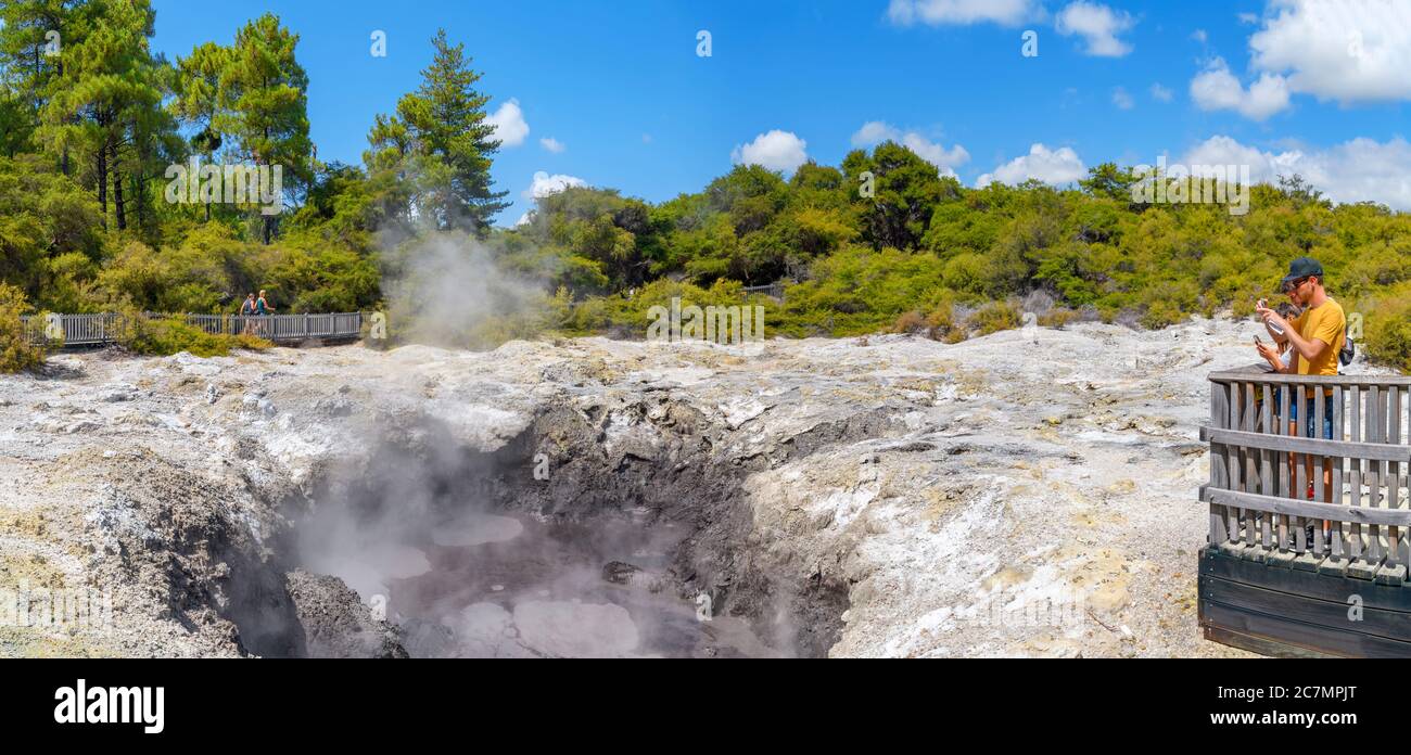 Coppia scattando fotografie di una piscina di fango al Wai-o-Tapu Thermal Wonderland, vicino a Rotorua, Nuova Zelanda Foto Stock