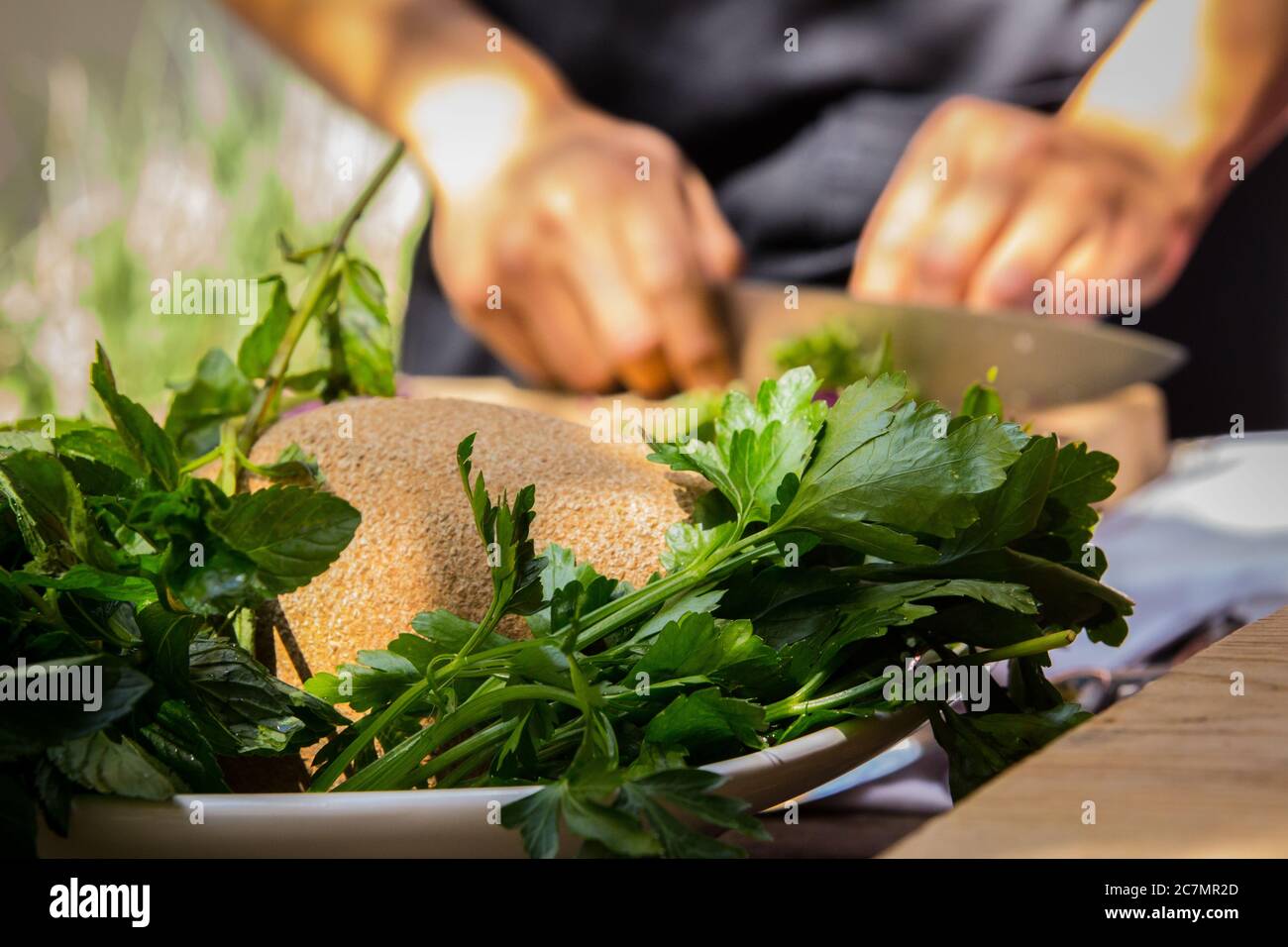 Primo piano di prezzemolo e tritare lo chef sullo sfondo Foto Stock