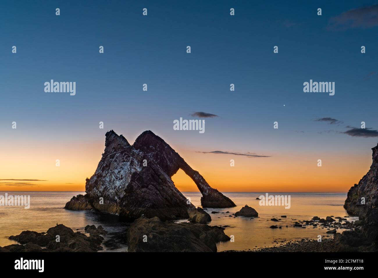 ARCO VIOLINO ROCCIA PORTKNOCKIE MORAY COSTA SCOZIA ESTATE MATTINA ALBA CON LUNA CRESCENT IN DECLINO E STELLA LUMINOSA IL PIANETA VENERE Foto Stock