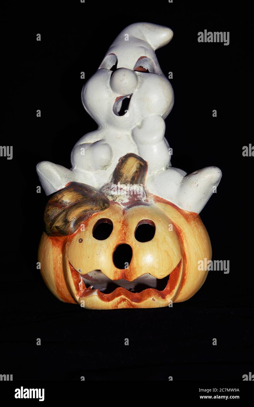 La zucca di Halloween fotografata con un fantasma isolato su uno sfondo nero Foto Stock