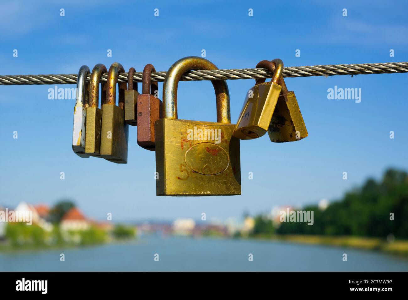 Lucchetto / lucchetto come simbolo e espressione di amore eterno romanticismo, coppia, e relazione d'amore. Città e fiume sfocati sullo sfondo Foto Stock