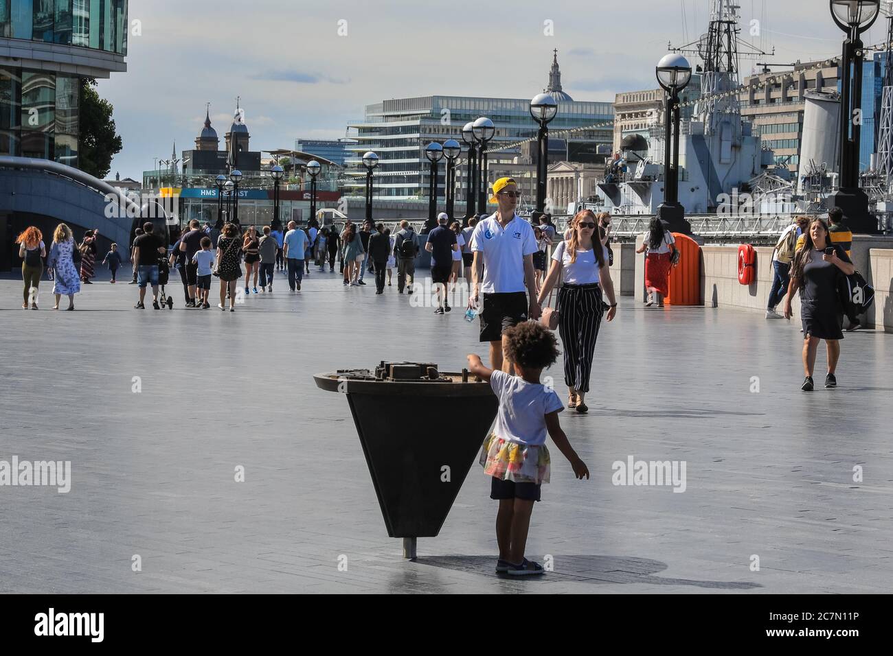 Londra, Regno Unito. 18 luglio 2020. Oggi, la gente cammina e si siede al sole nella zona intorno al municipio e al Potters Field Park. Il centro di Londra sembrava diventare più affollato oggi con più persone che lasciano le loro case per godersi il tempo soleggiato. Le regole di allontanamento sociale sembravano essere rispettate nella maggior parte dei luoghi, ma alcune aree sono già sempre affollate. Credit: Imageplotter/Alamy Live News Foto Stock