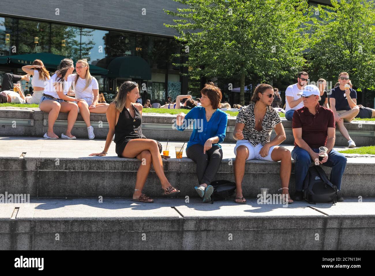 Londra, Regno Unito. 18 luglio 2020. Oggi, la gente cammina e si siede al sole nella zona intorno al municipio e al Potters Field Park. Il centro di Londra sembrava diventare più affollato oggi con più persone che lasciano le loro case per godersi il tempo soleggiato. Le regole di allontanamento sociale sembravano essere rispettate nella maggior parte dei luoghi, ma alcune aree sono già sempre affollate. Credit: Imageplotter/Alamy Live News Foto Stock