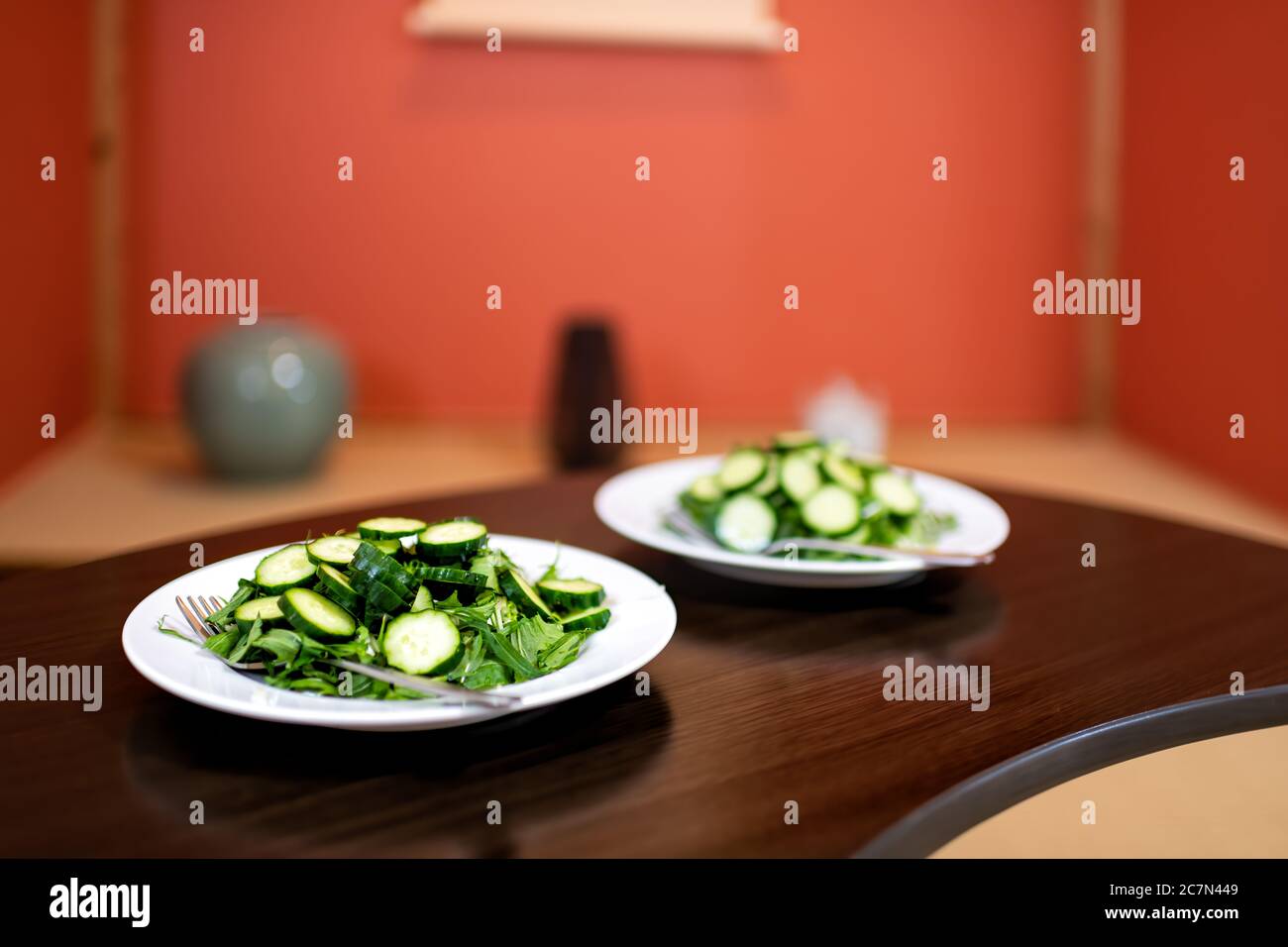 Tavolo di legno e pasto con insalata verde con cetrioli giapponesi e verdure di mizuna all'interno della casa in hotel ryokan o camera domestica con a tradizionale Foto Stock