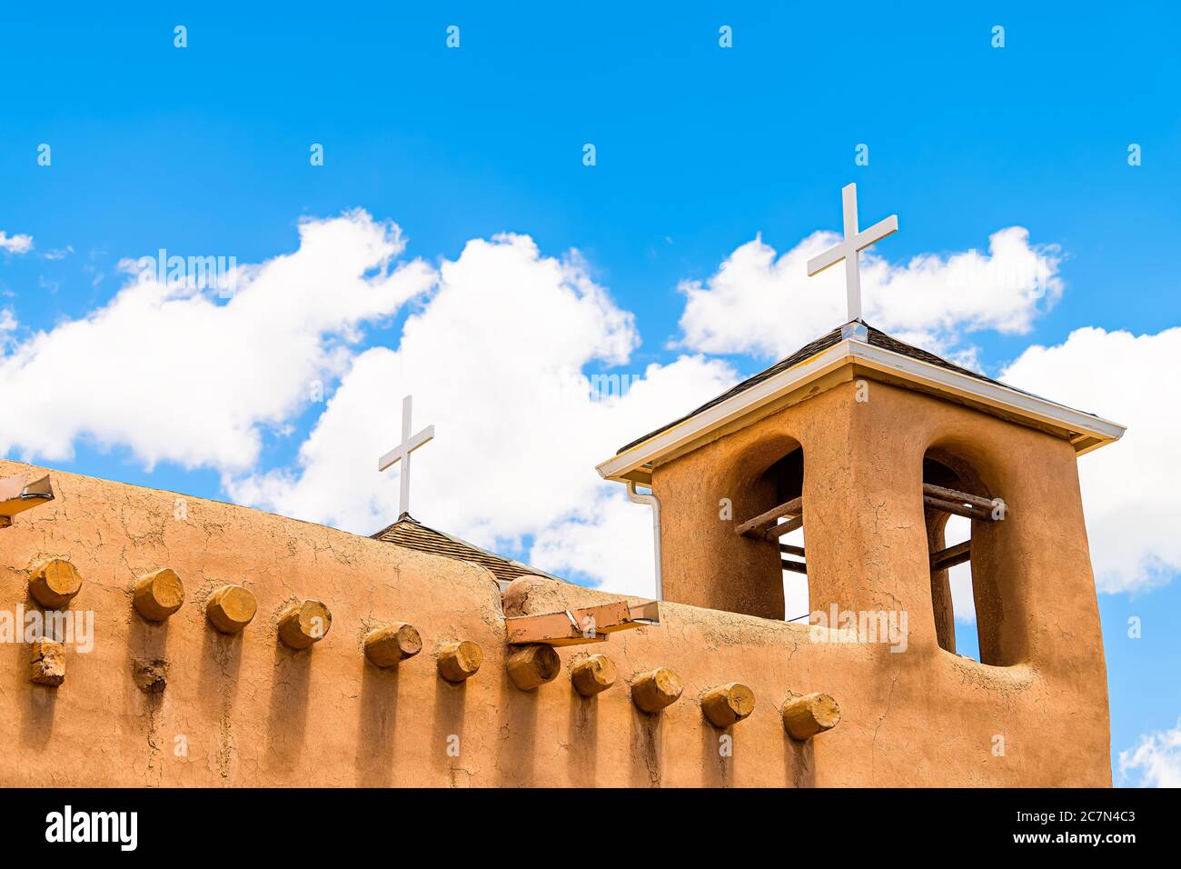 Ranchos de Taos closeup della chiesa di San Francisco de Aseis campanile con croce nel New Mexico basso angolo guardando verso il cielo blu Foto Stock