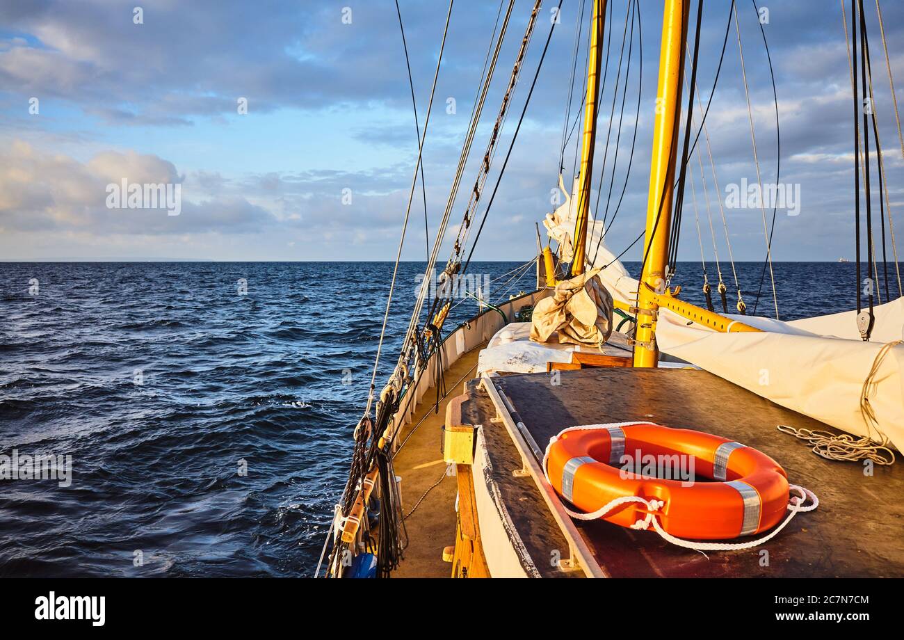 Lifebuoy sul ponte di una vecchia goletta a vela al tramonto. Foto Stock