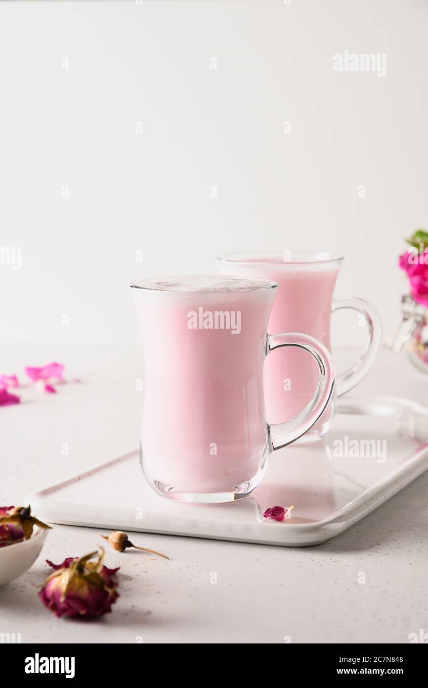 Latte di luna di rosa in bicchieri per dormire su sfondo bianco. Primo piano Foto Stock