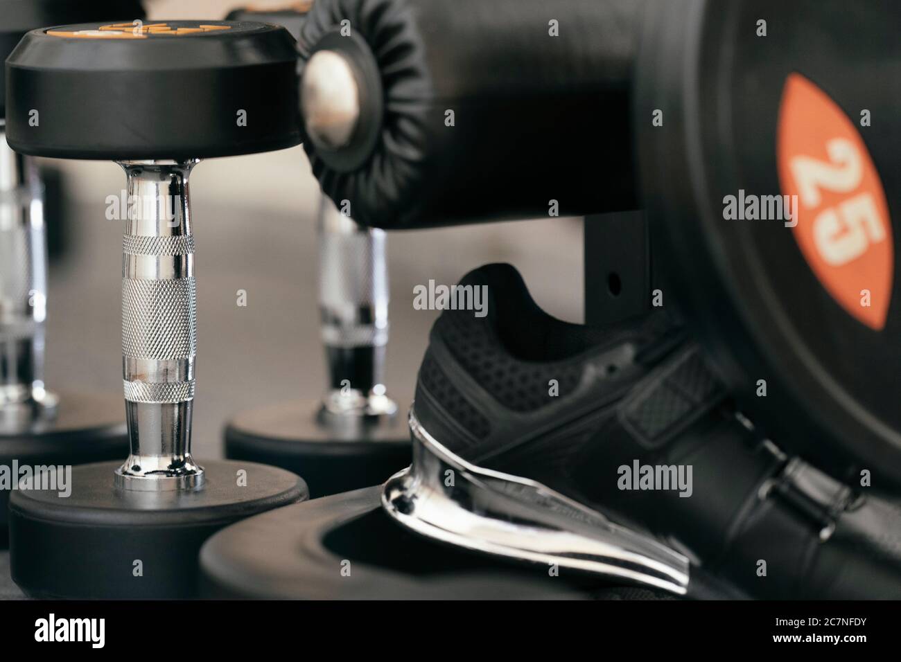 Attrezzatura da palestra, dettaglio closeup della piastra pesi, manubri, Powerlifting, sollevamento pesi, scarpe tallone rialzato Foto Stock