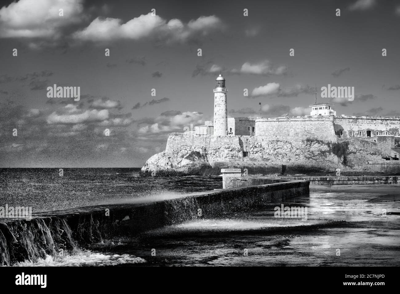 Faro e fortezza di El Morro a l'Avana durante una tempesta tropicale con onde che si infrangono sul muro di Malecon Foto Stock