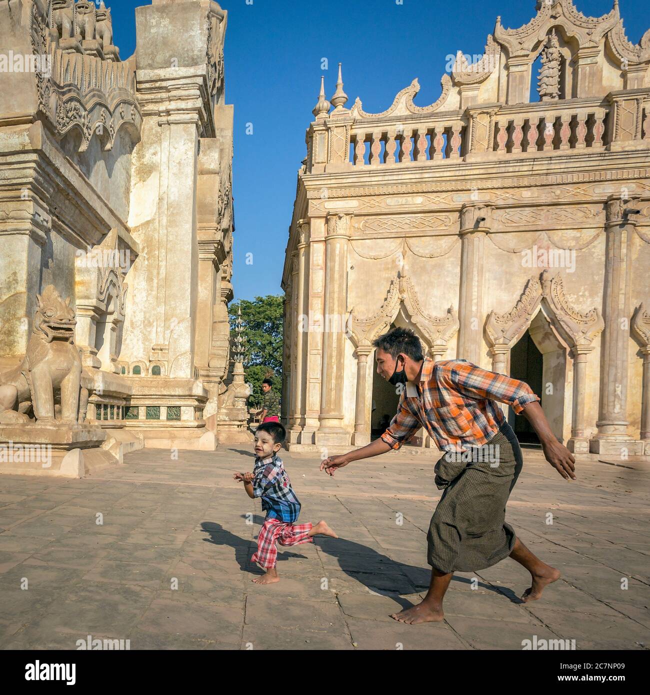 Un uomo insegue il suo figlio al tempio di Ananda a Bagan, Myanmar Foto Stock