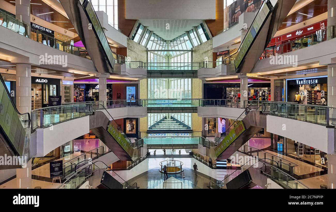 Vista interna del centro commerciale cittadino con scale mobili e negozi diversi piani costruiti in stile architettonico moderno Foto Stock Vista interna del centro commerciale cittadino con scale mobili e negozi diversi piani costruiti in stile architettonico moderno Foto Stock