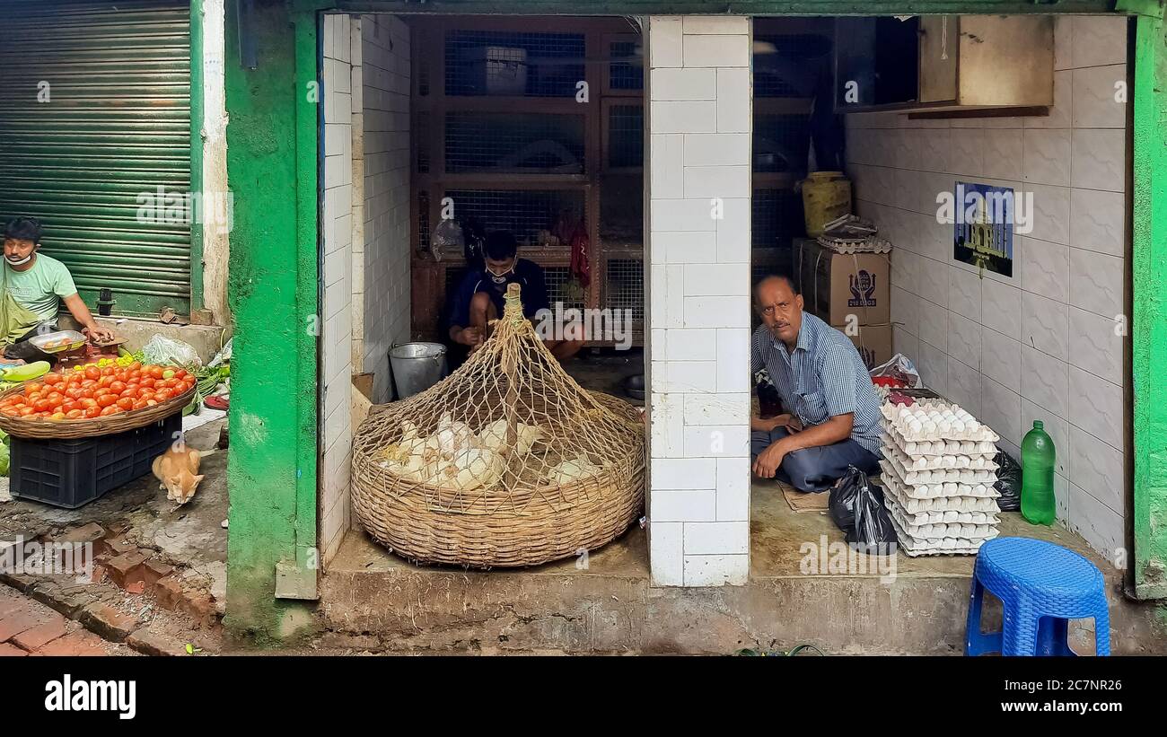 Pollame vivo conservato in paniere coperto di rete a Negozio di carne di pollo in un mercato locale della città di Kolkata Foto Stock