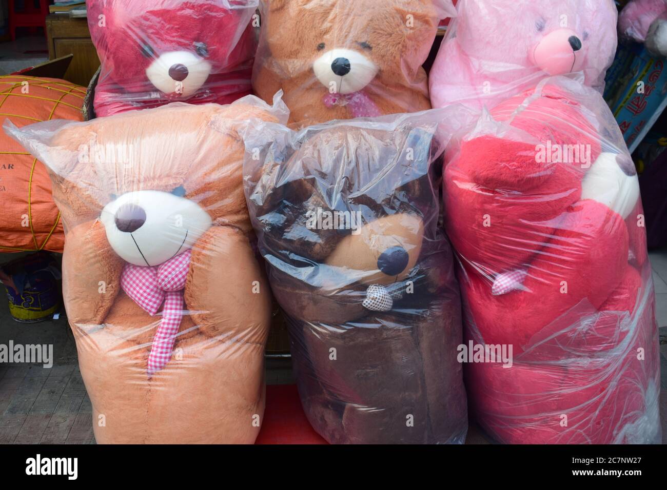 Giocattoli colorati in sacchetti di plastica nel mercato Foto Stock