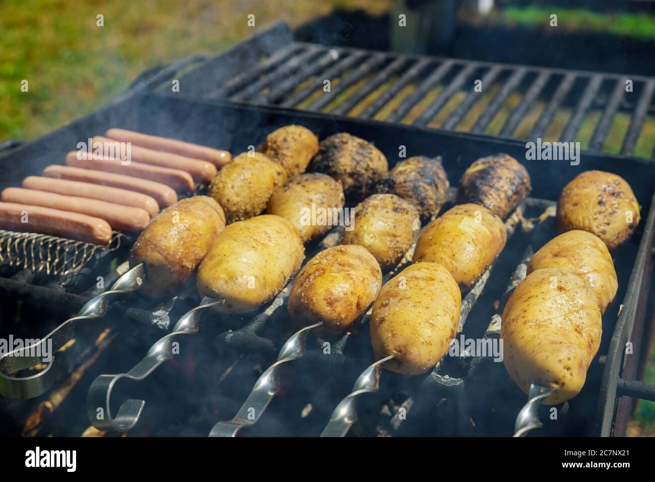 Patate intere cotte al forno con griglia saon su spiedini. Foto Stock