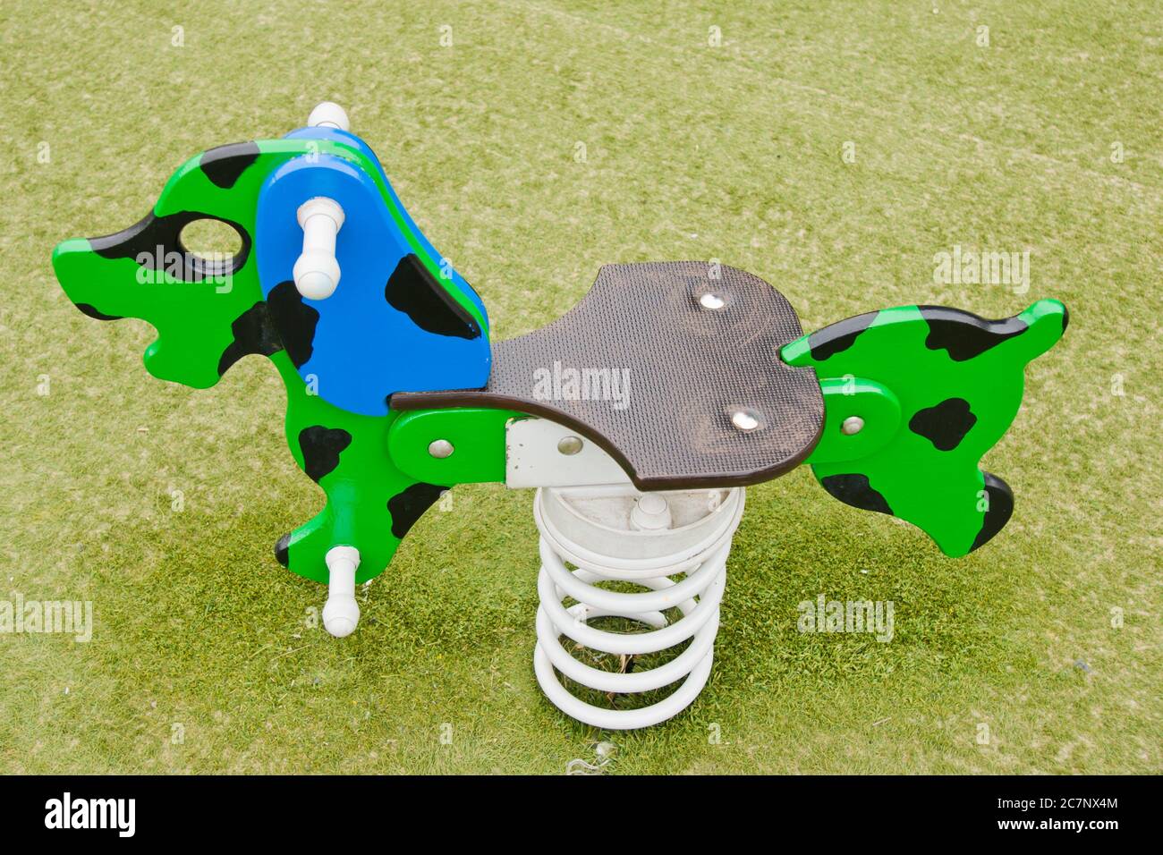 Colpo di closeup di un'attrezzatura multicolore per il parco giochi di un cane dondolante a. un parco Foto Stock