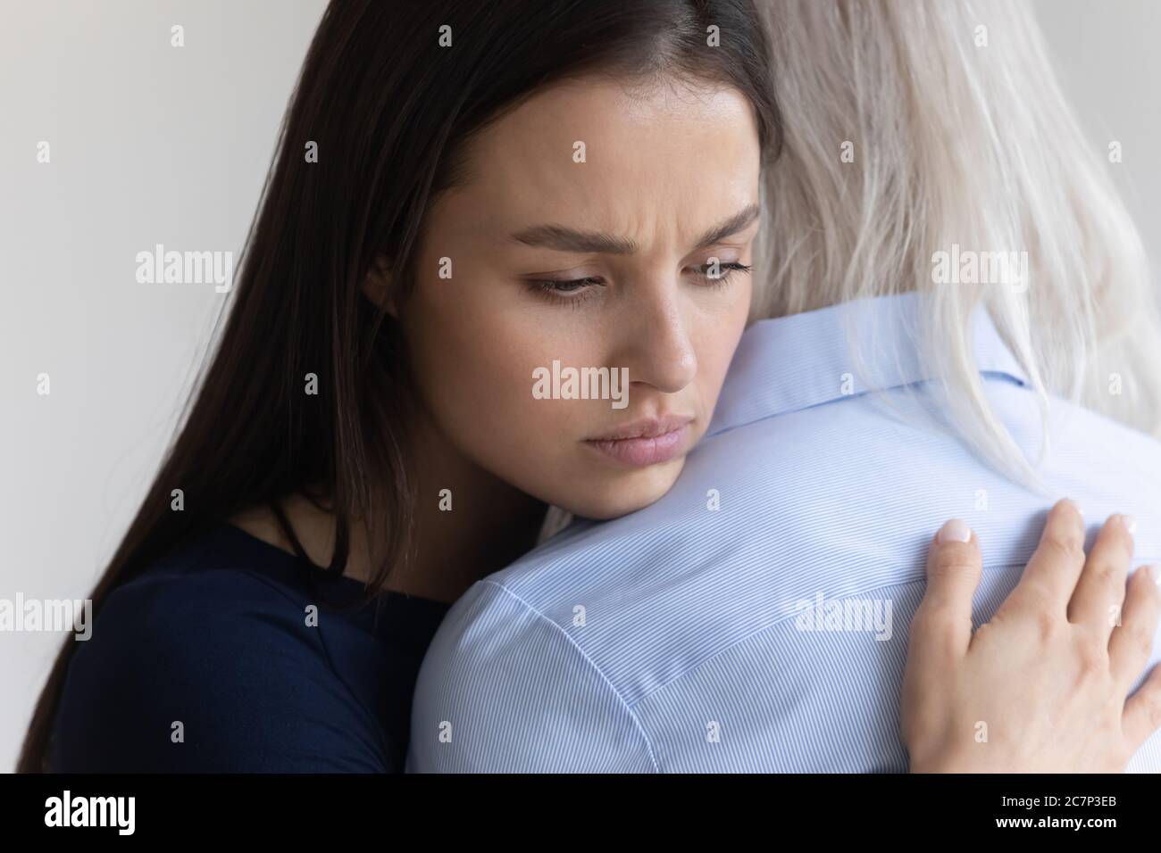 Figlia abbraccia la madre anziana che la pitying mostrando la vista closeup di simpatia Foto Stock
