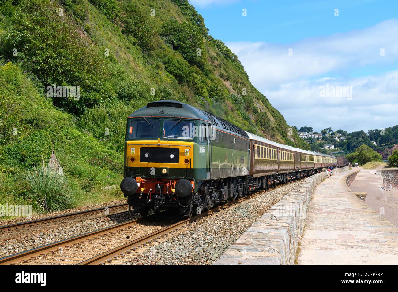 Inglese Riviera treno di stato trasportato da British Railways due-tono Verde liveried Classe 47/8, No. D1935 Roger Hoskins passa il muro di mare Teignmouth Foto Stock